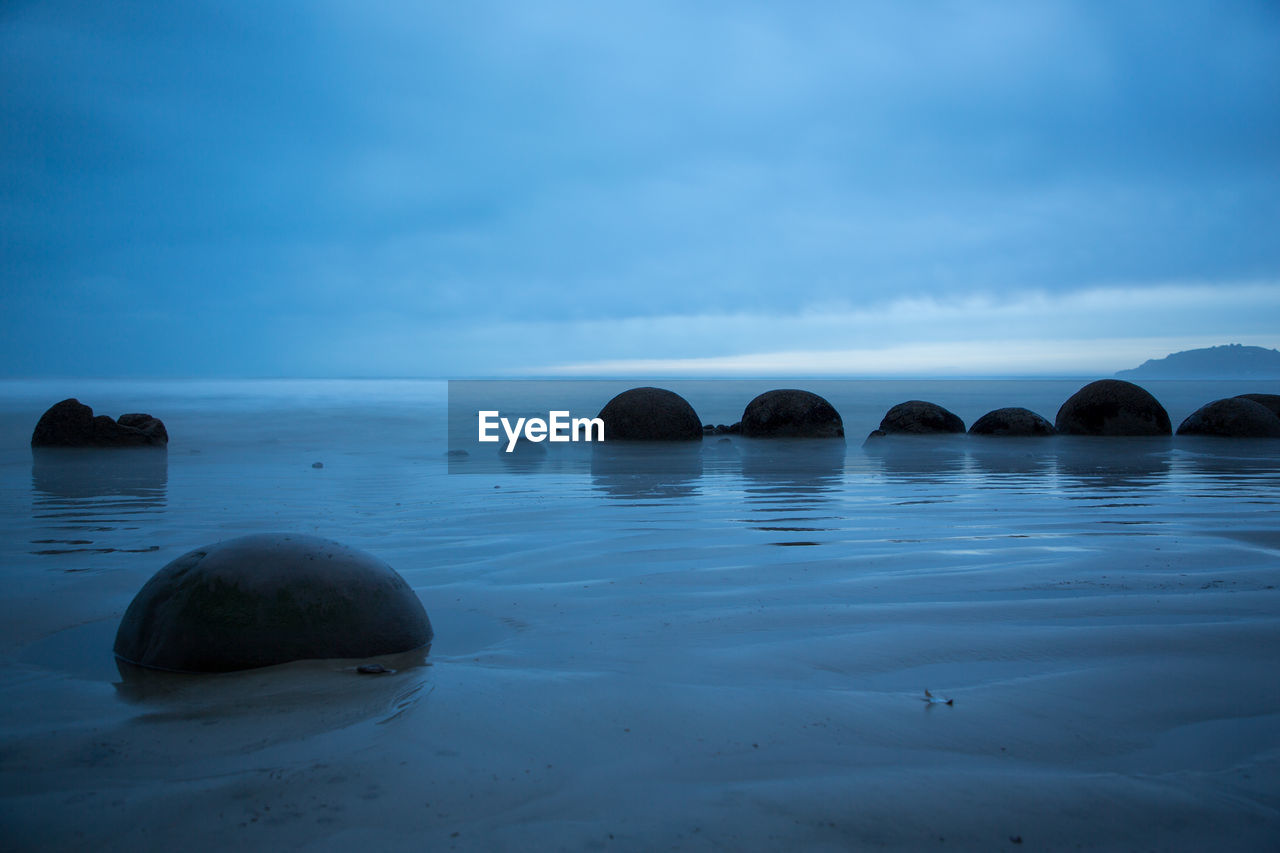 Rocks in sea against sky