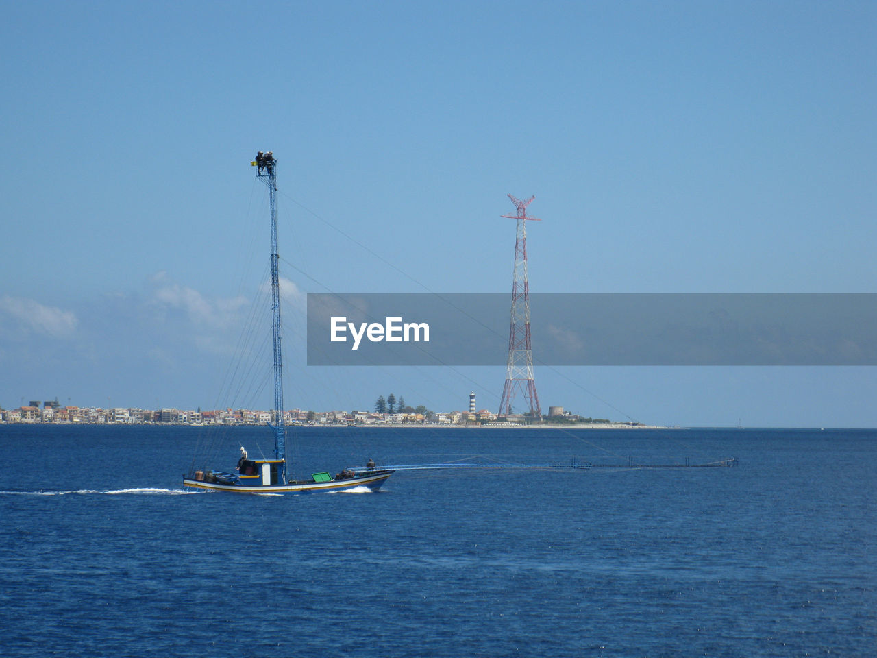 Boat sailing in sea against blue sky