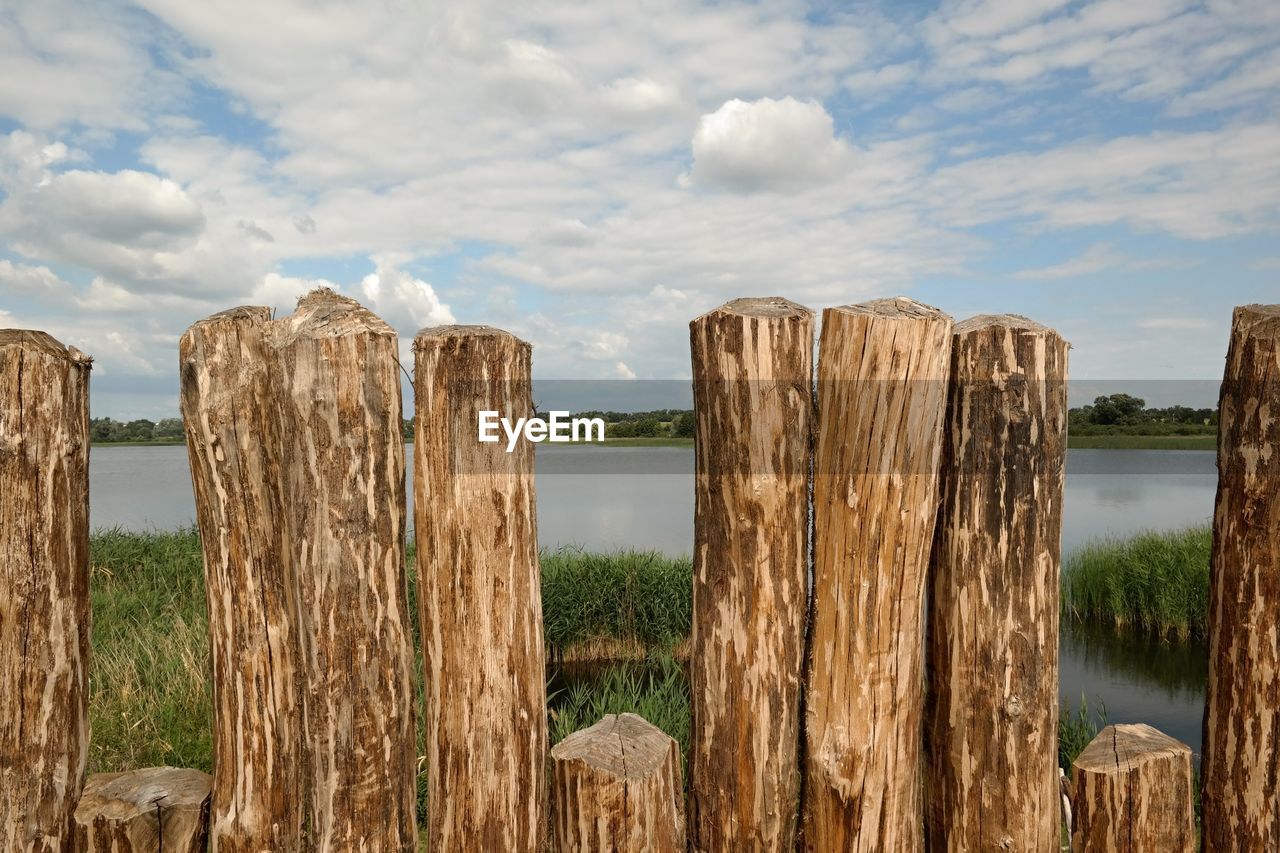 PANORAMIC SHOT OF WOODEN POST ON LANDSCAPE