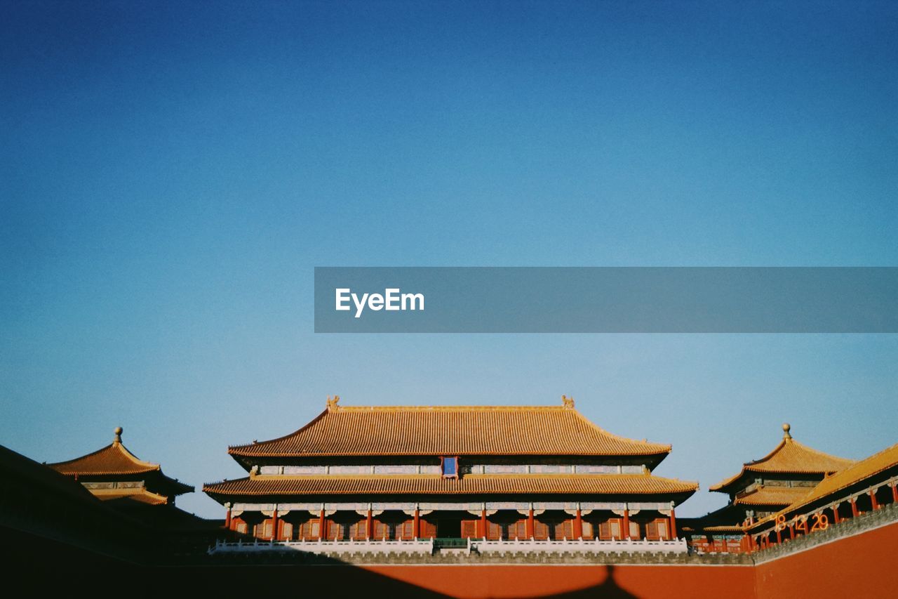 Low angle view of temple against clear blue sky