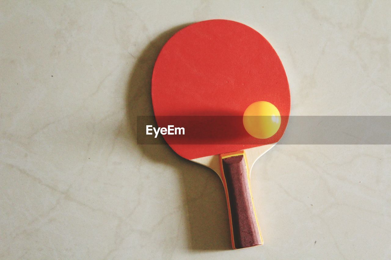 High angle view of tennis racket with ball on floor