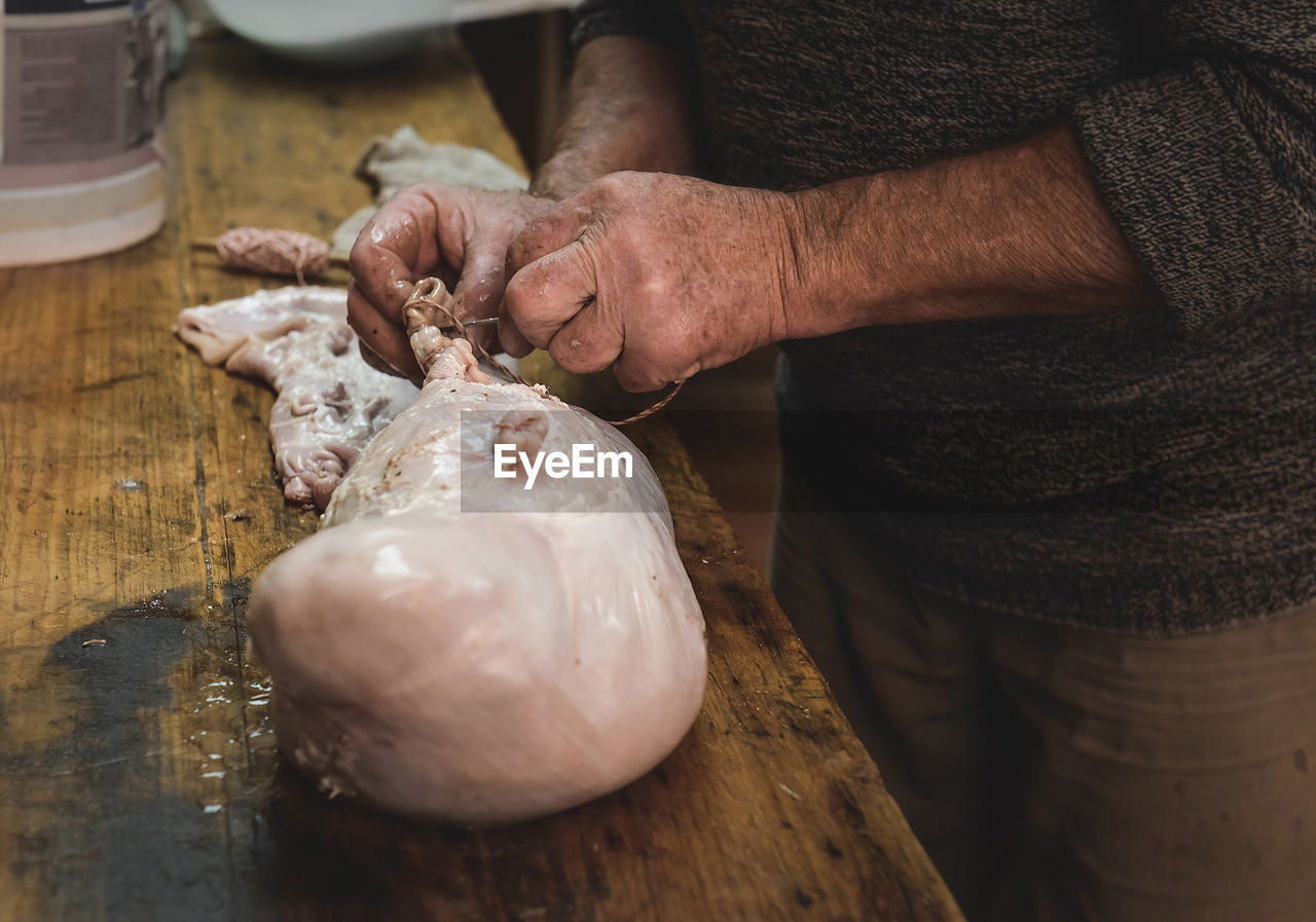 midsection of man holding seashell on table