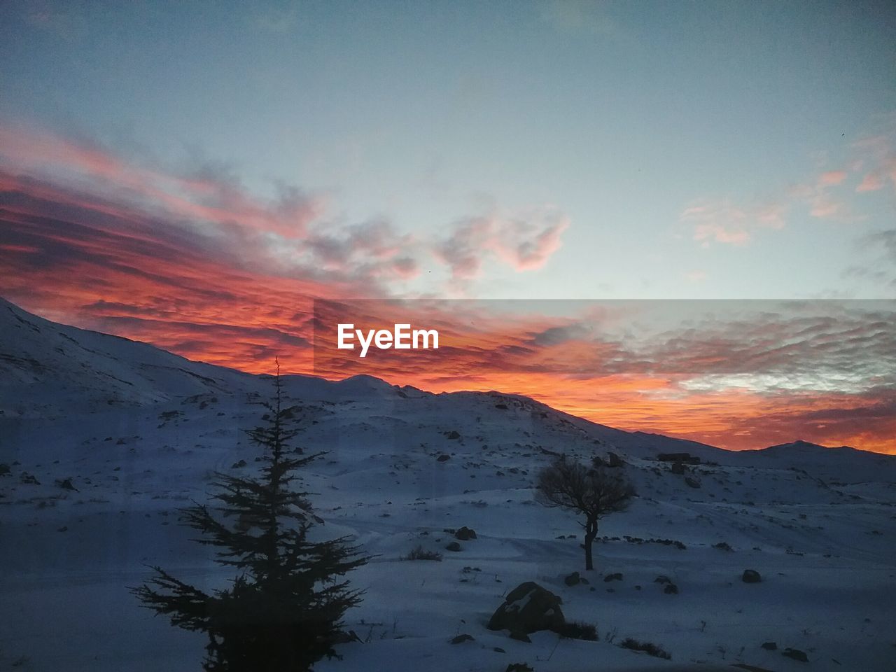 SUN SHINING THROUGH CLOUDS OVER MOUNTAINS