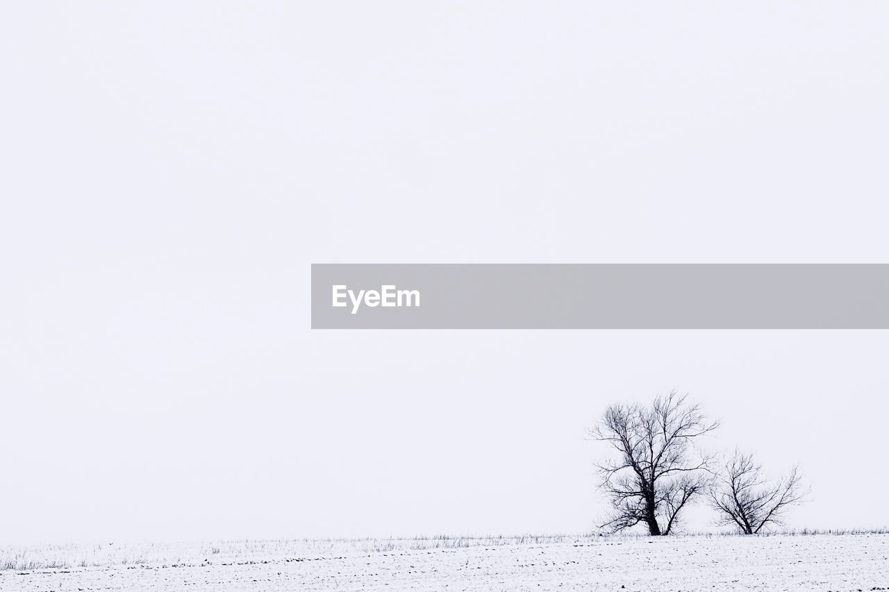 Snow covered landscape against clear sky