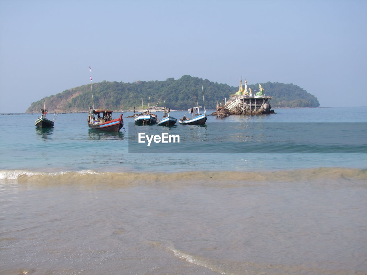 Boats on sea against clear sky