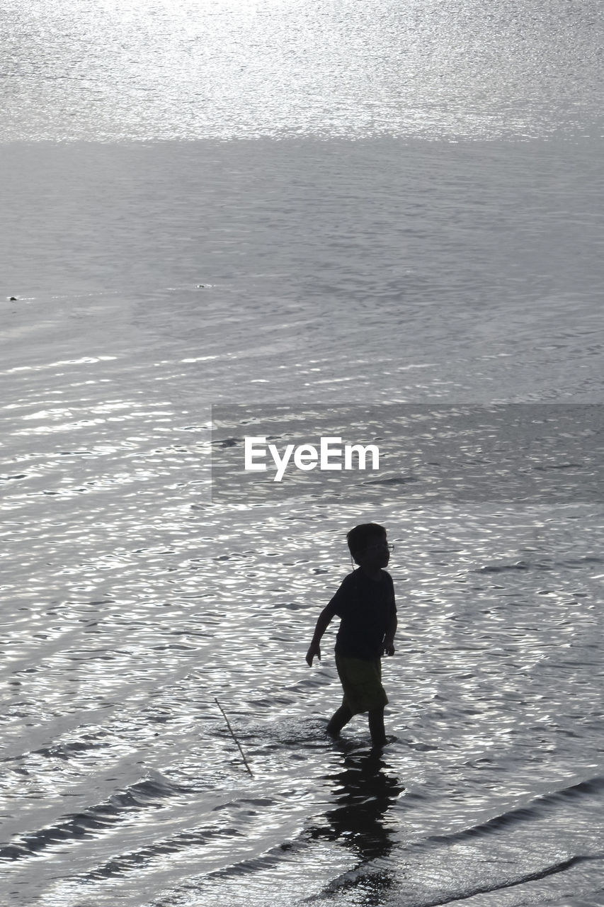 FULL LENGTH OF MAN STANDING IN SEA