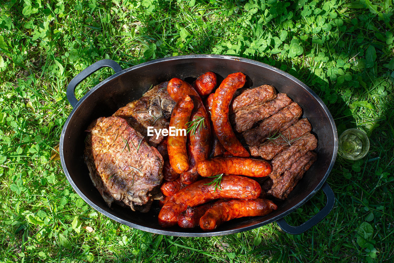 Roasted barbeque in a dish - sausages, steaks, kebabs and chicken meat with rosemary