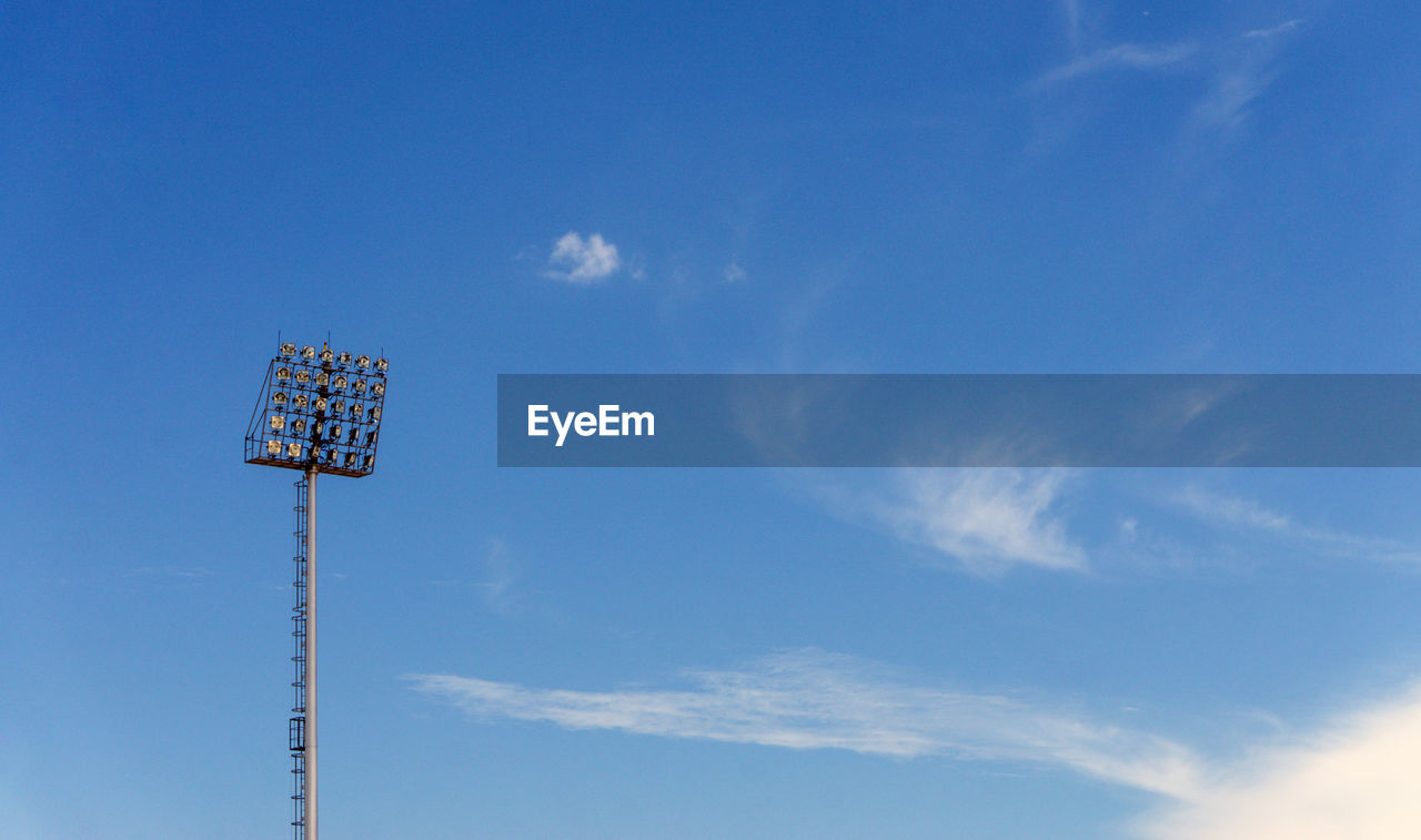 Low angle view of floodlight against blue sky