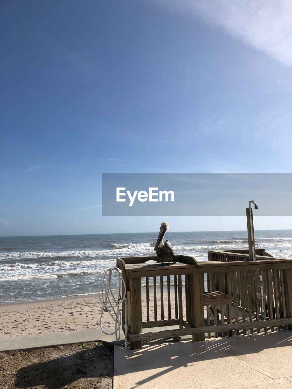 LOUNGE CHAIRS ON BEACH AGAINST SKY