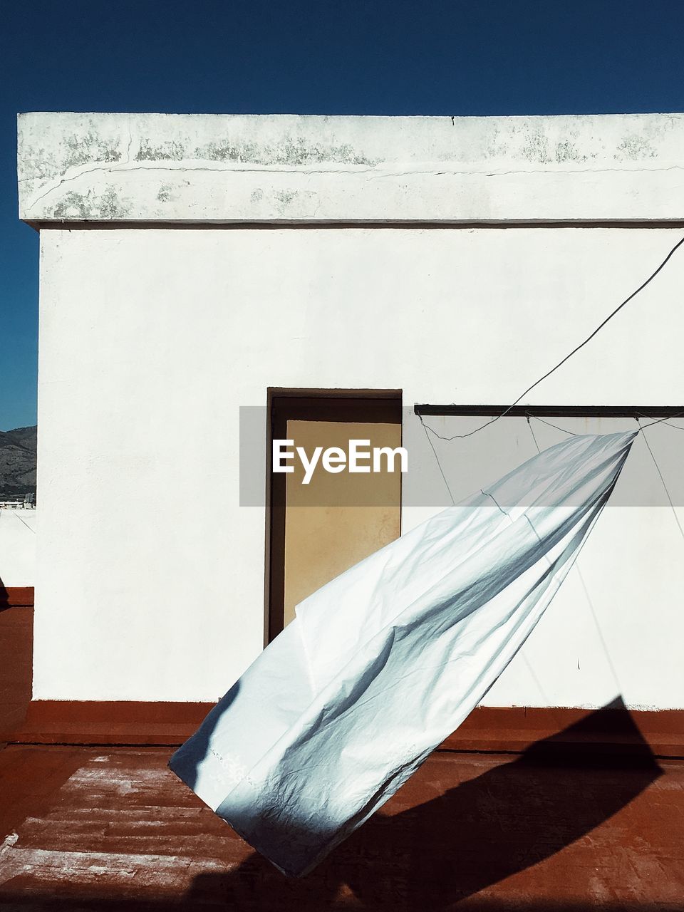 White textile hanging against built structure