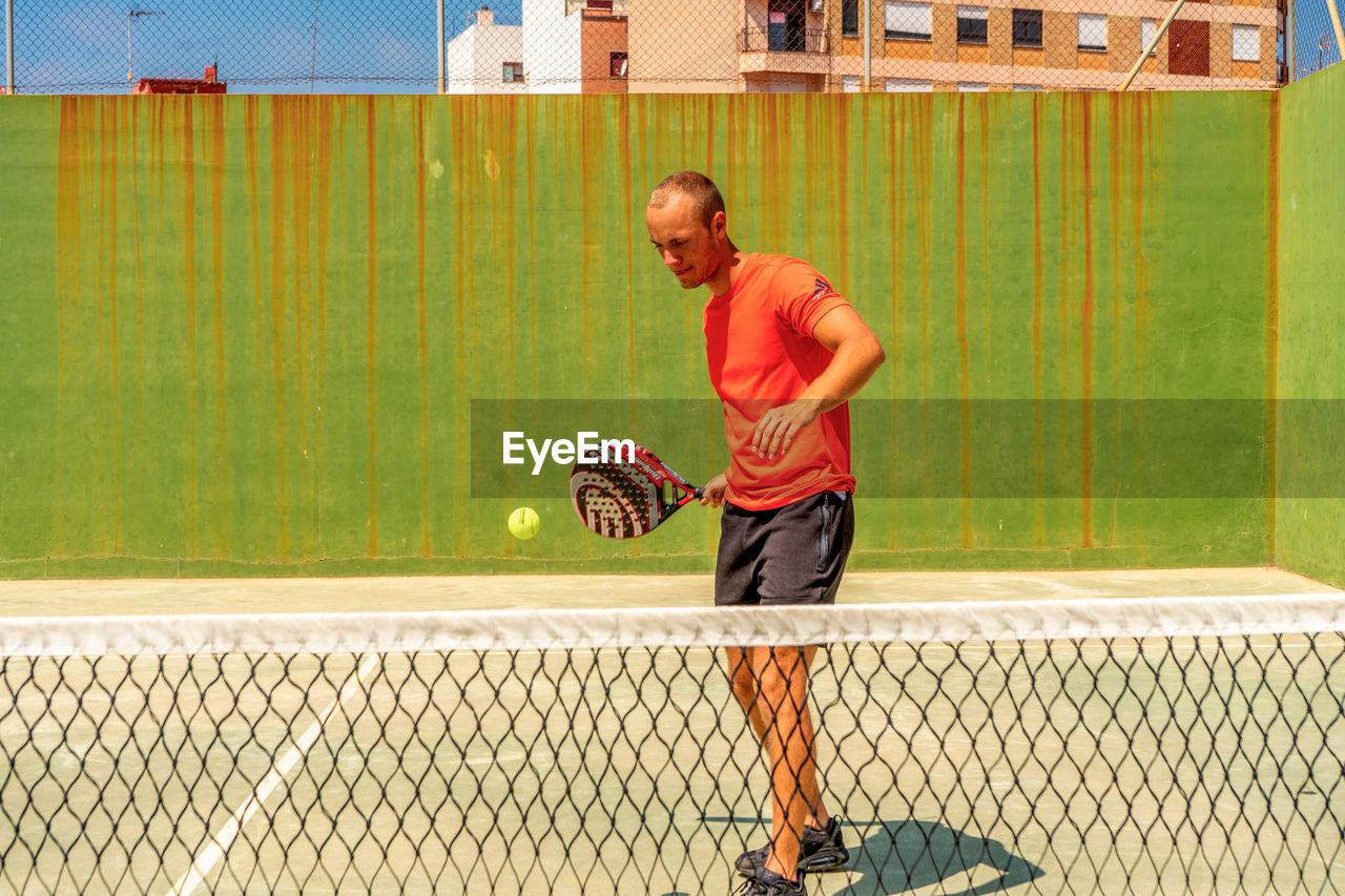 FULL LENGTH OF MAN PLAYING WITH BALL IN BACKGROUND