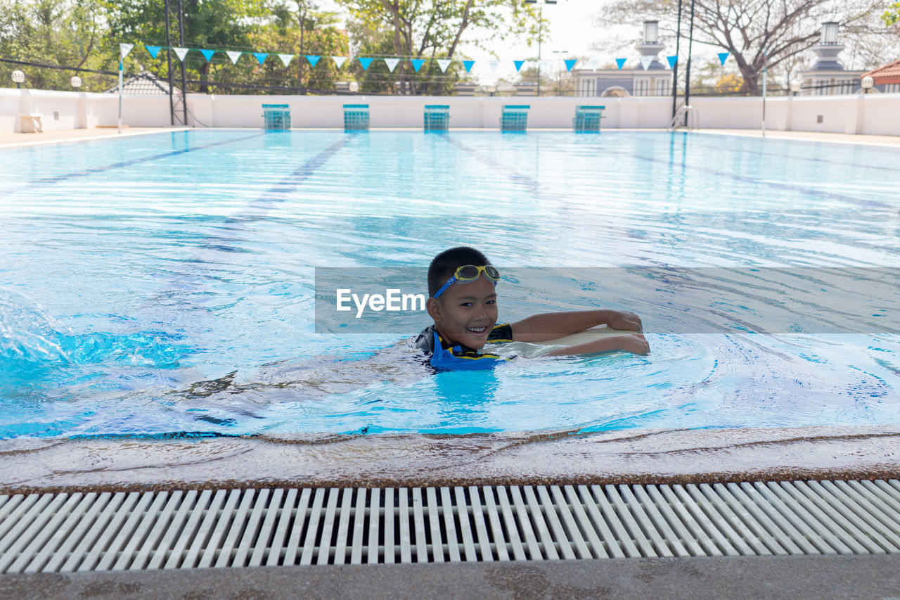 Smiling boy swimming in pool