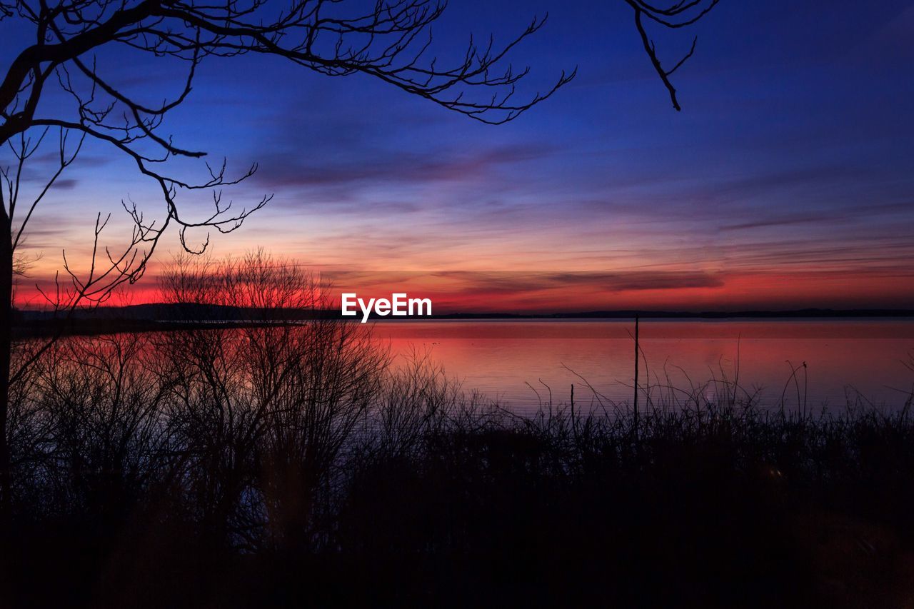 SCENIC VIEW OF LAKE AGAINST ORANGE SKY