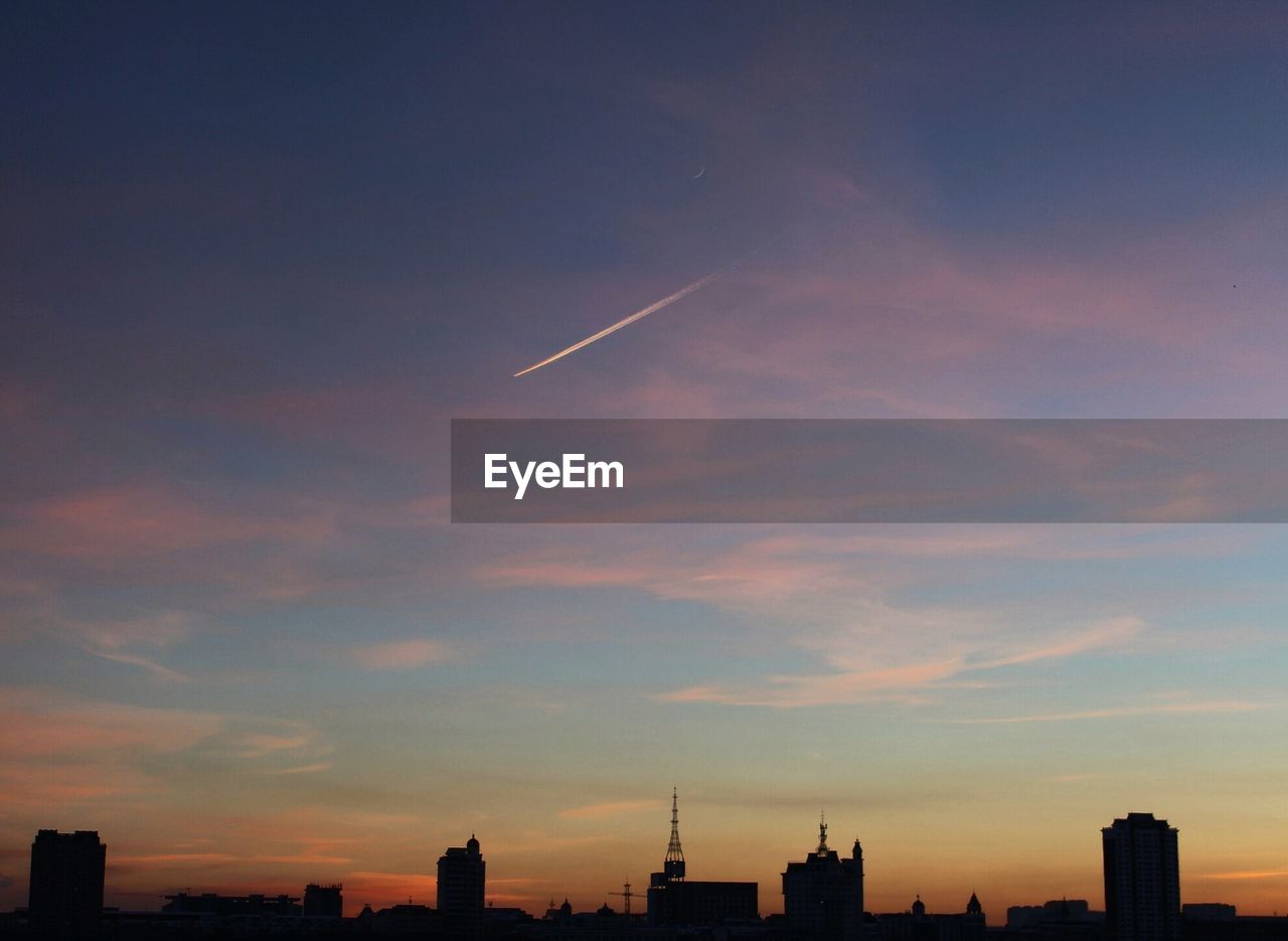 SILHOUETTE OF CITY AGAINST SKY AT SUNSET