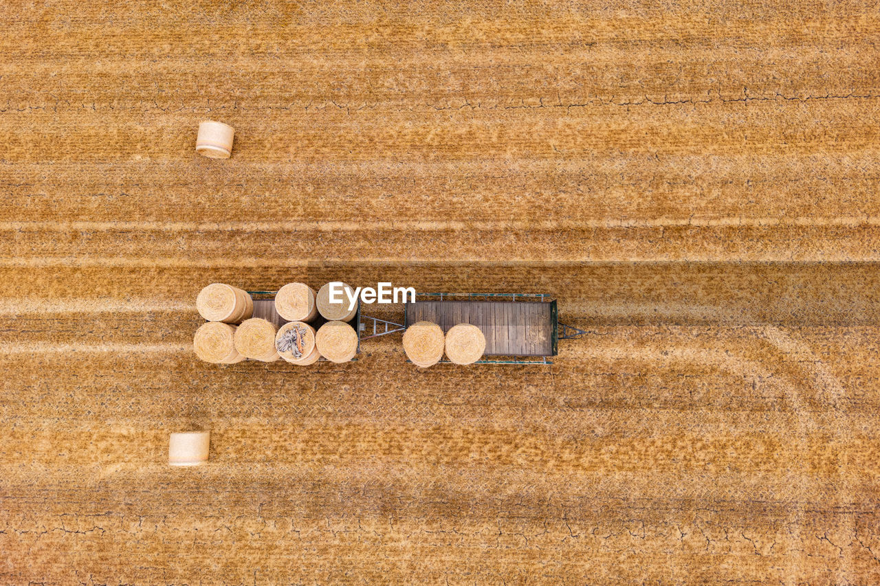 Hay bales stored on two trailers on a harvested agricultural field in summer, drone photo, germany