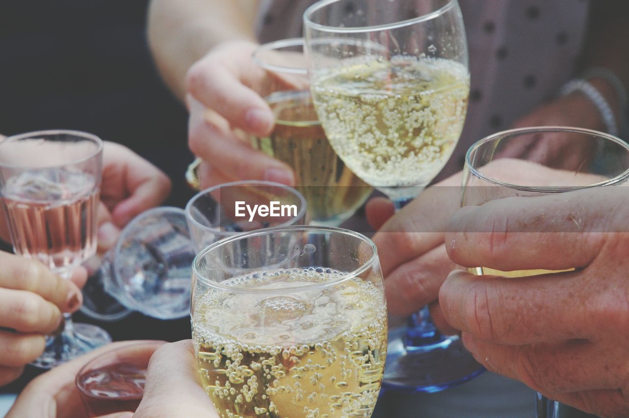 Close-up of people holding champagne and making a toast