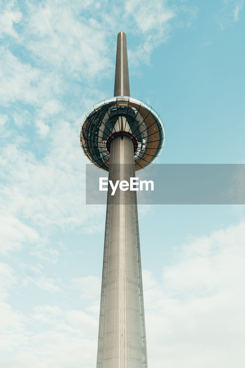 Low angle view of communications tower against cloudy sky