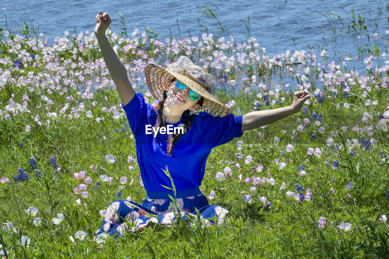 MIDSECTION OF WOMAN WITH FLOWERS ON PLANT