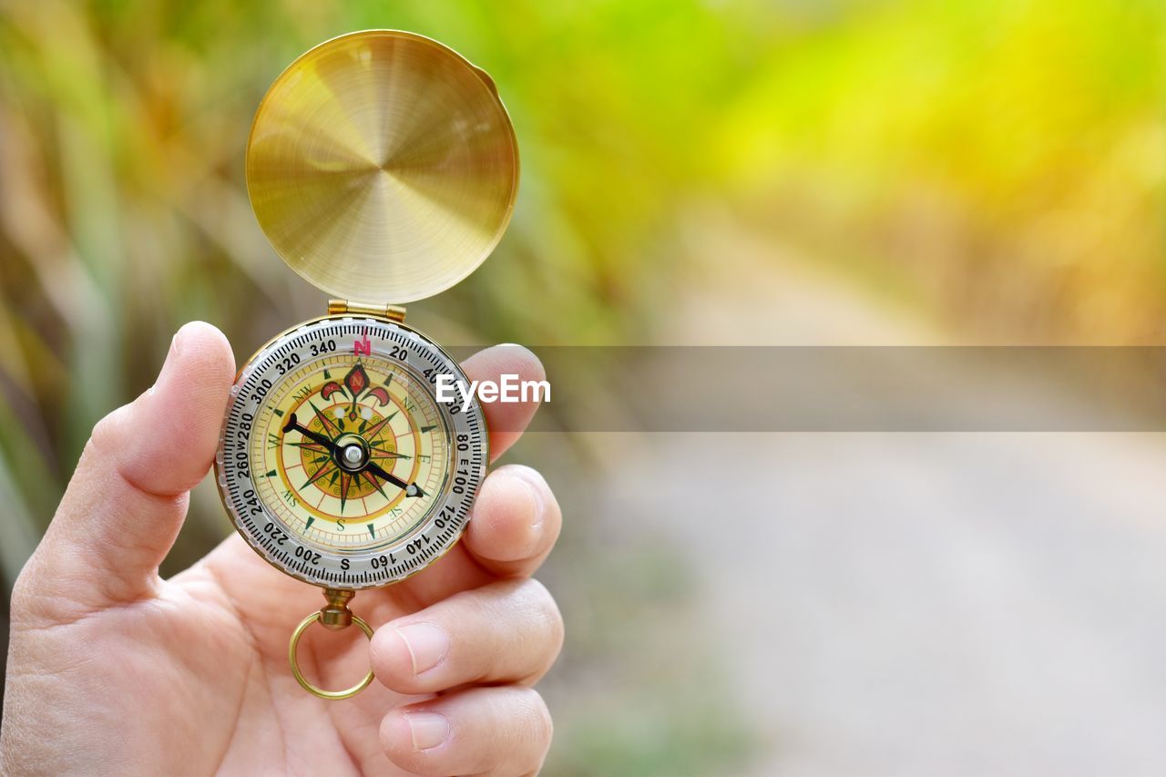 Close-up of hand holding navigational compass