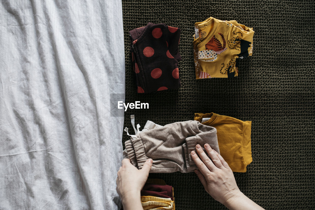 Womans hands folding children clothes