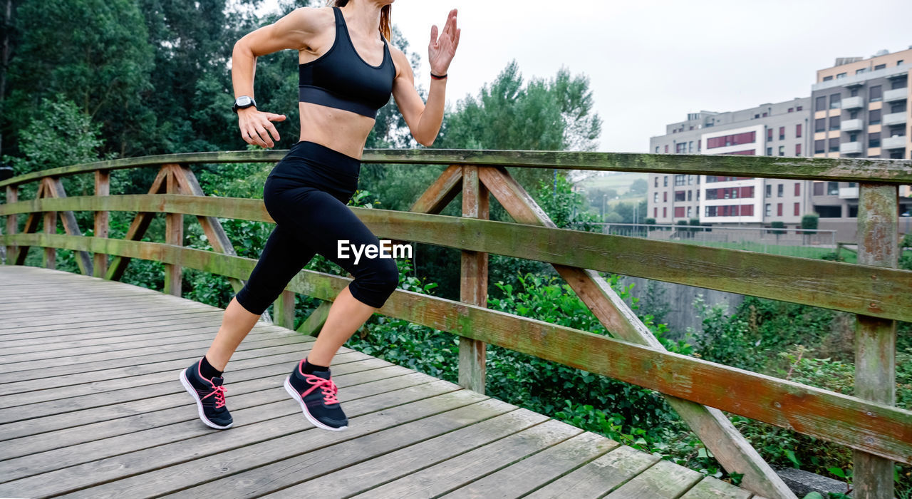 Unrecognizable athlete woman running through an urban park