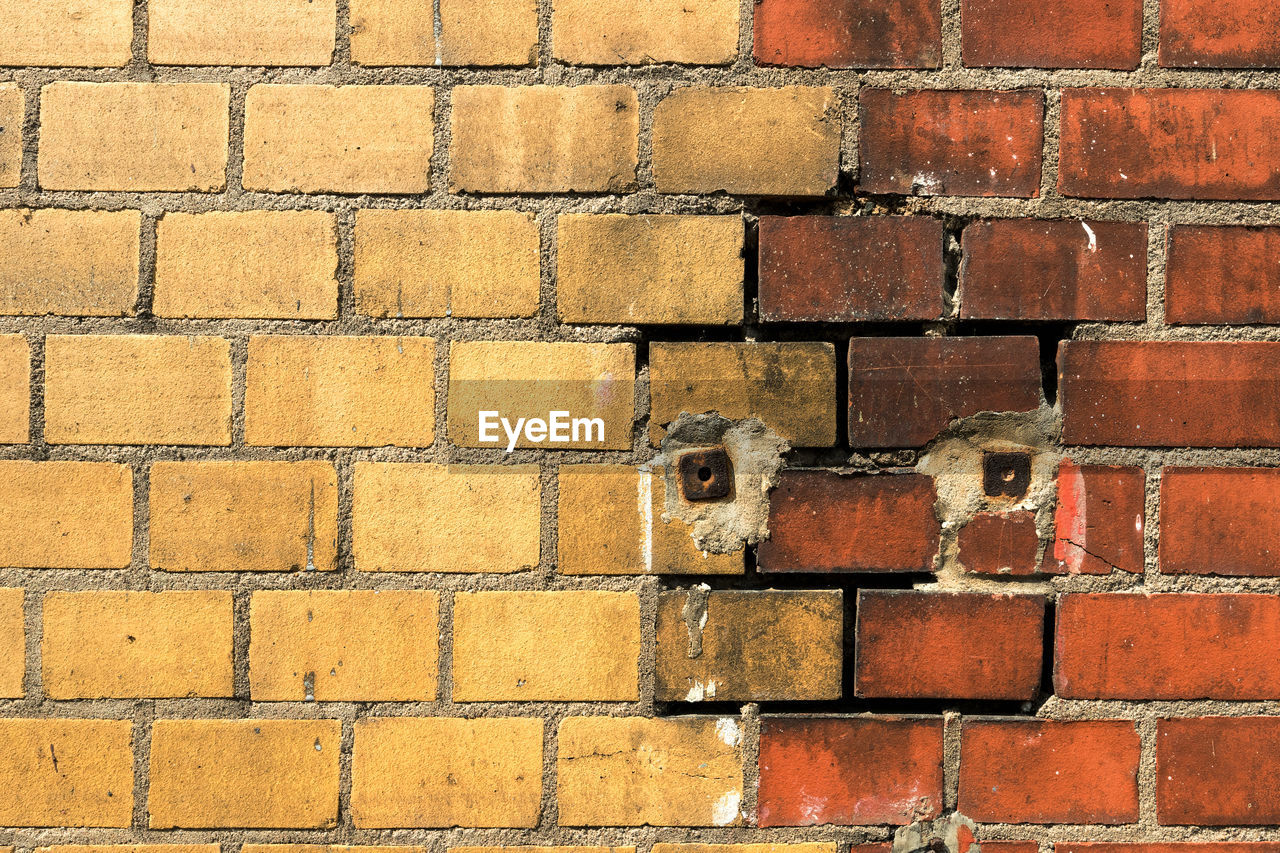 FULL FRAME SHOT OF BRICK WALL ON COBBLESTONE STREET