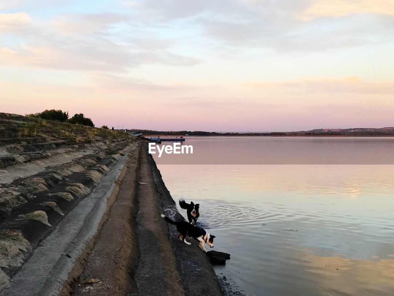 PANORAMIC SHOT OF MAN ON BEACH AGAINST SKY DURING SUNSET