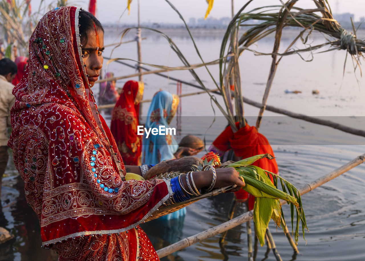 Portrait of women in traditional clothing at event by river 