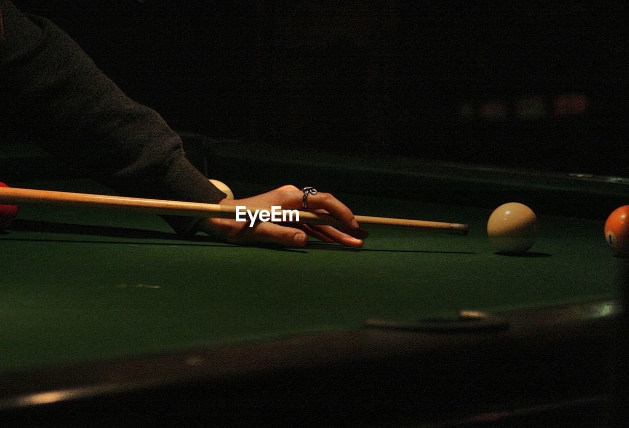 Cropped hands of man playing with snooker on table