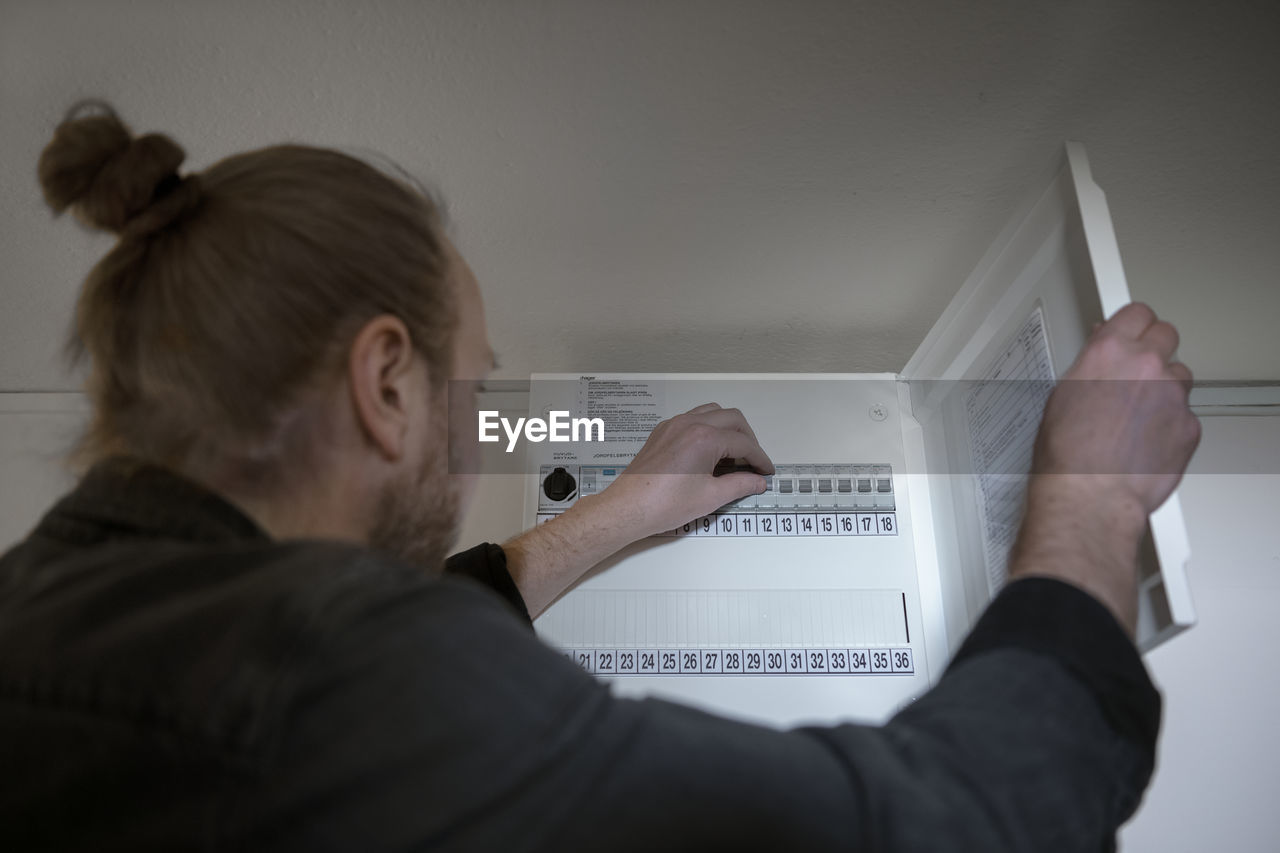 Man checking fuse box at home