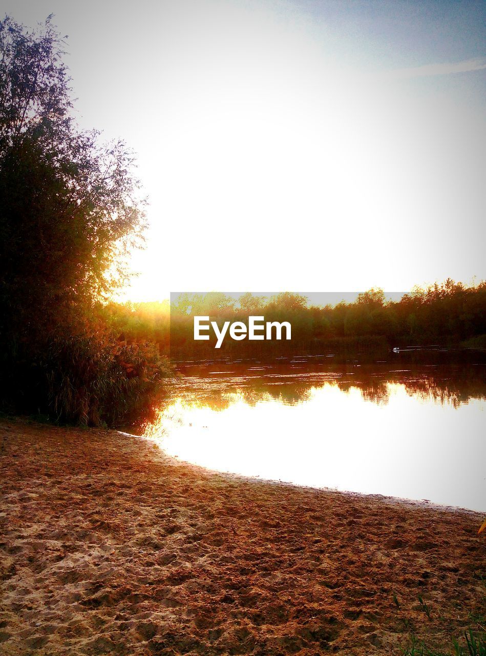 SCENIC VIEW OF LAKE AGAINST CLEAR SKY AT SUNSET