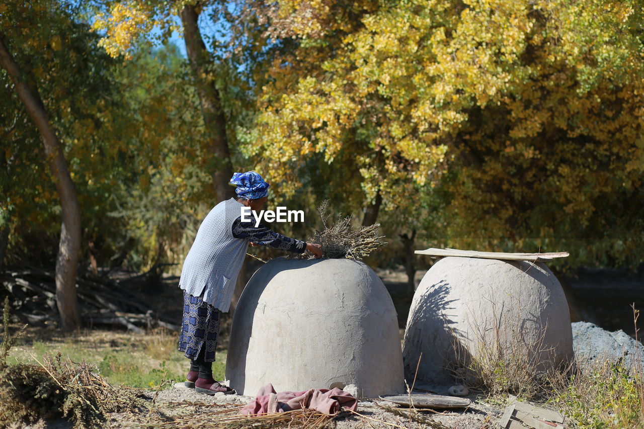 Man on field by trees in forest during autumn