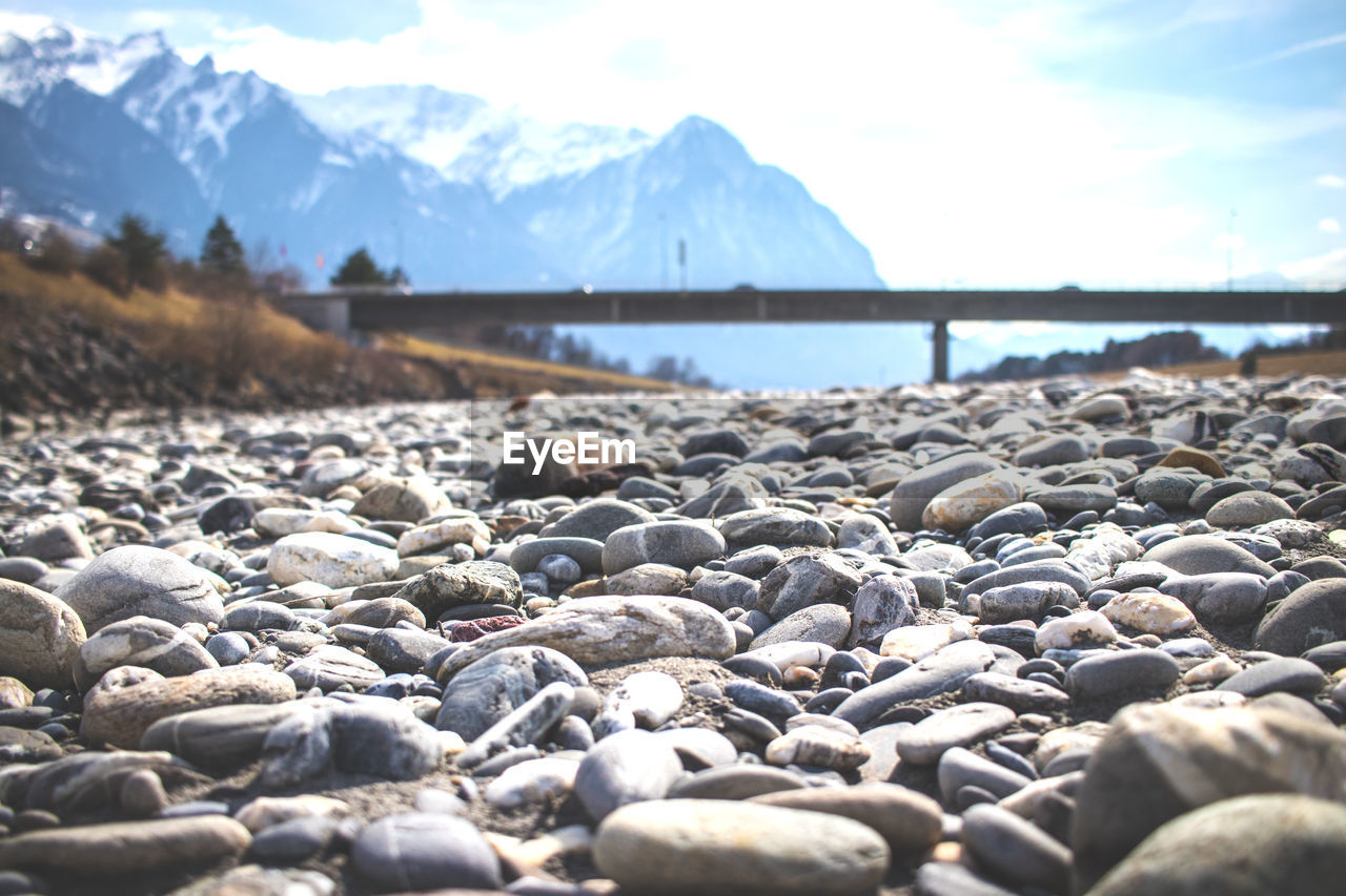 Surface level of pebble beach against sky