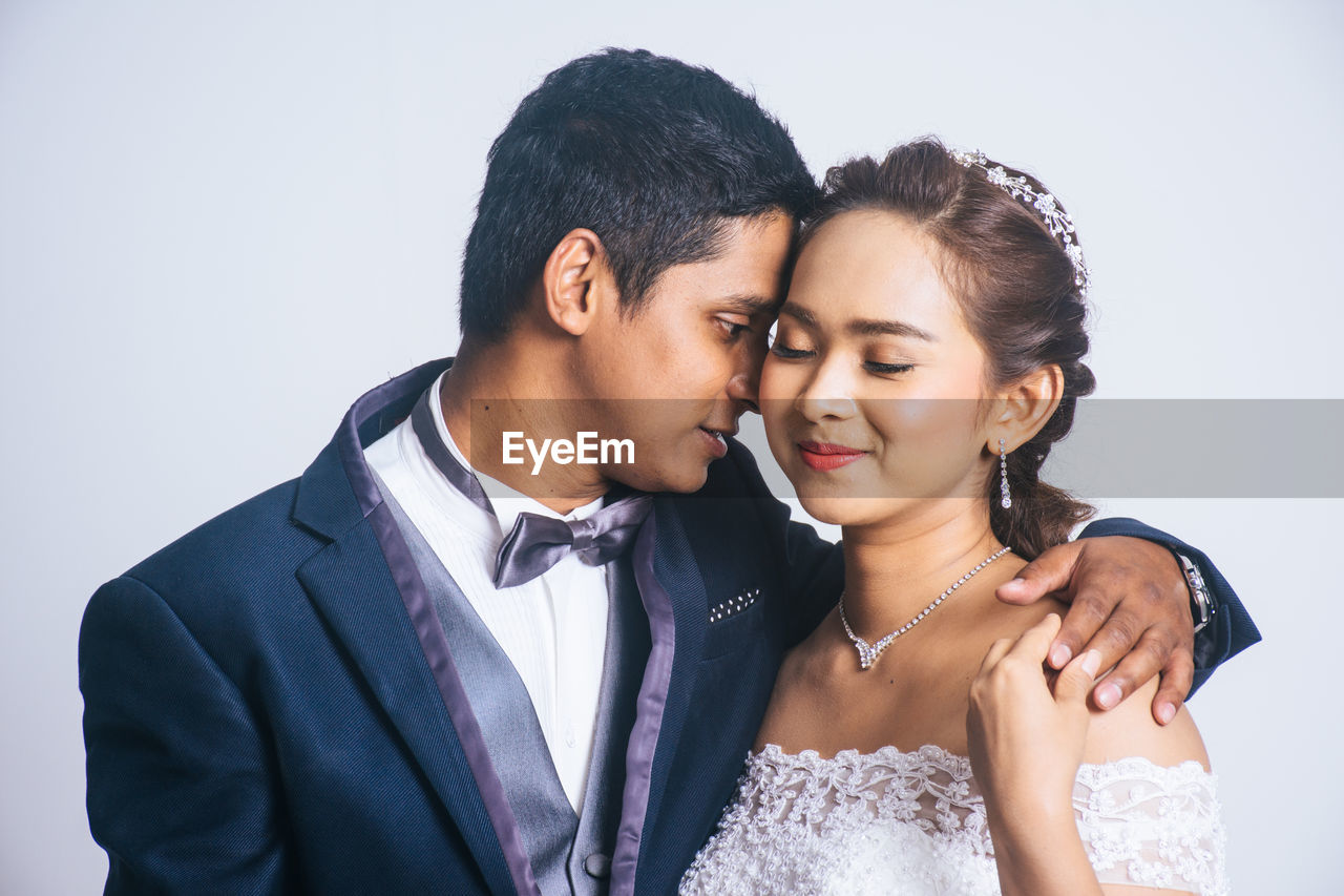 YOUNG COUPLE AGAINST WHITE BACKGROUND