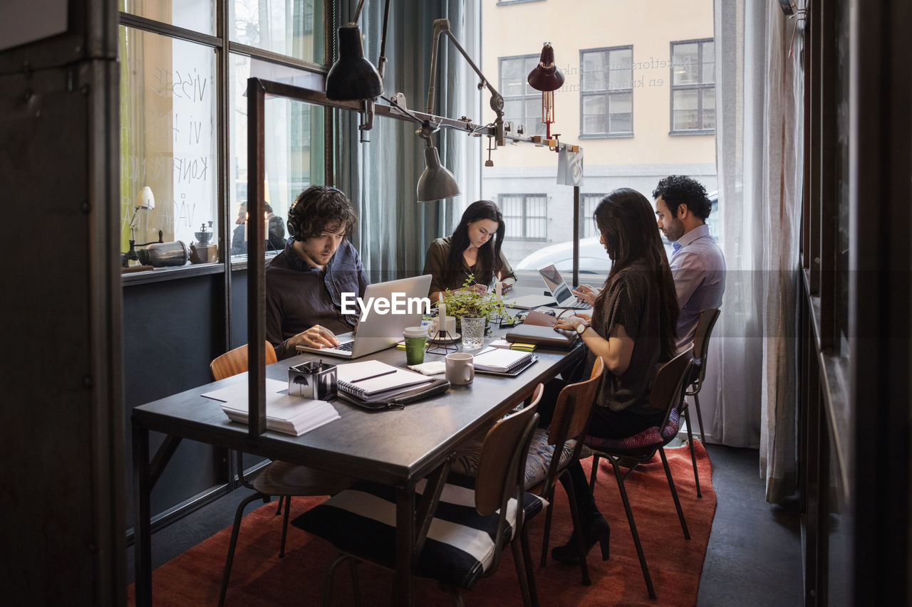 Male and female bloggers working at table in modern office