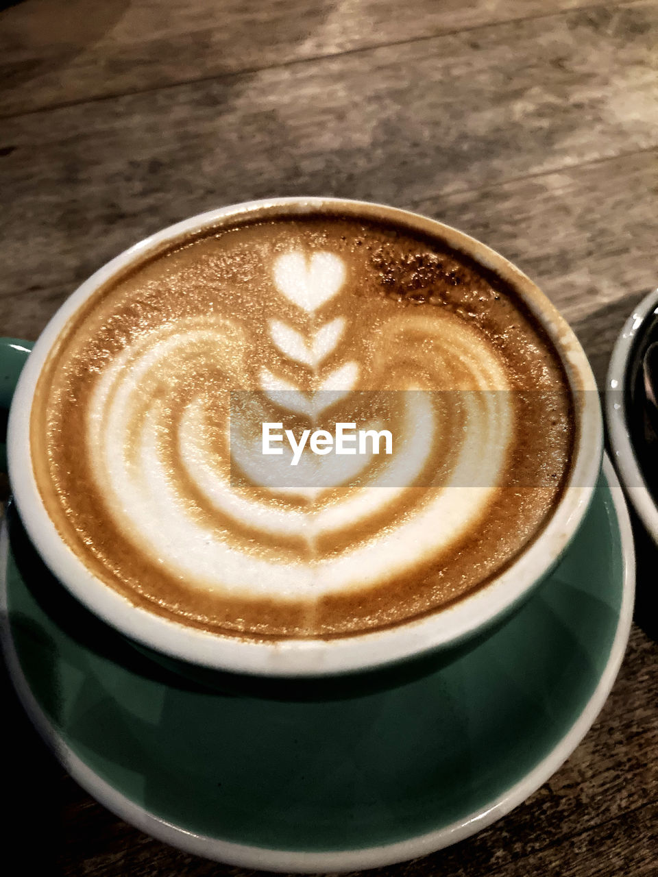 CLOSE-UP OF CAPPUCCINO COFFEE ON TABLE