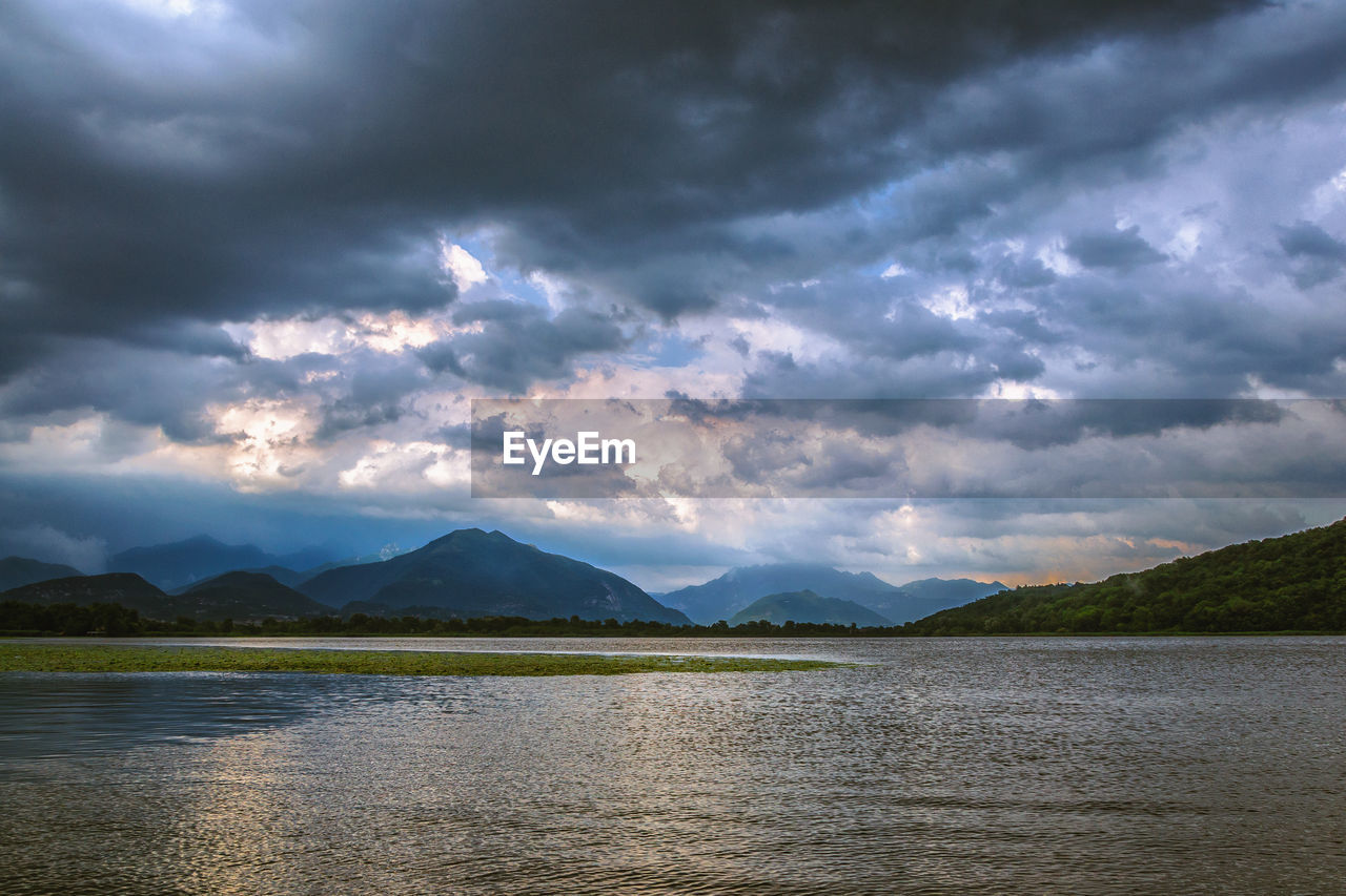 Scenic view of lake against dramatic sky