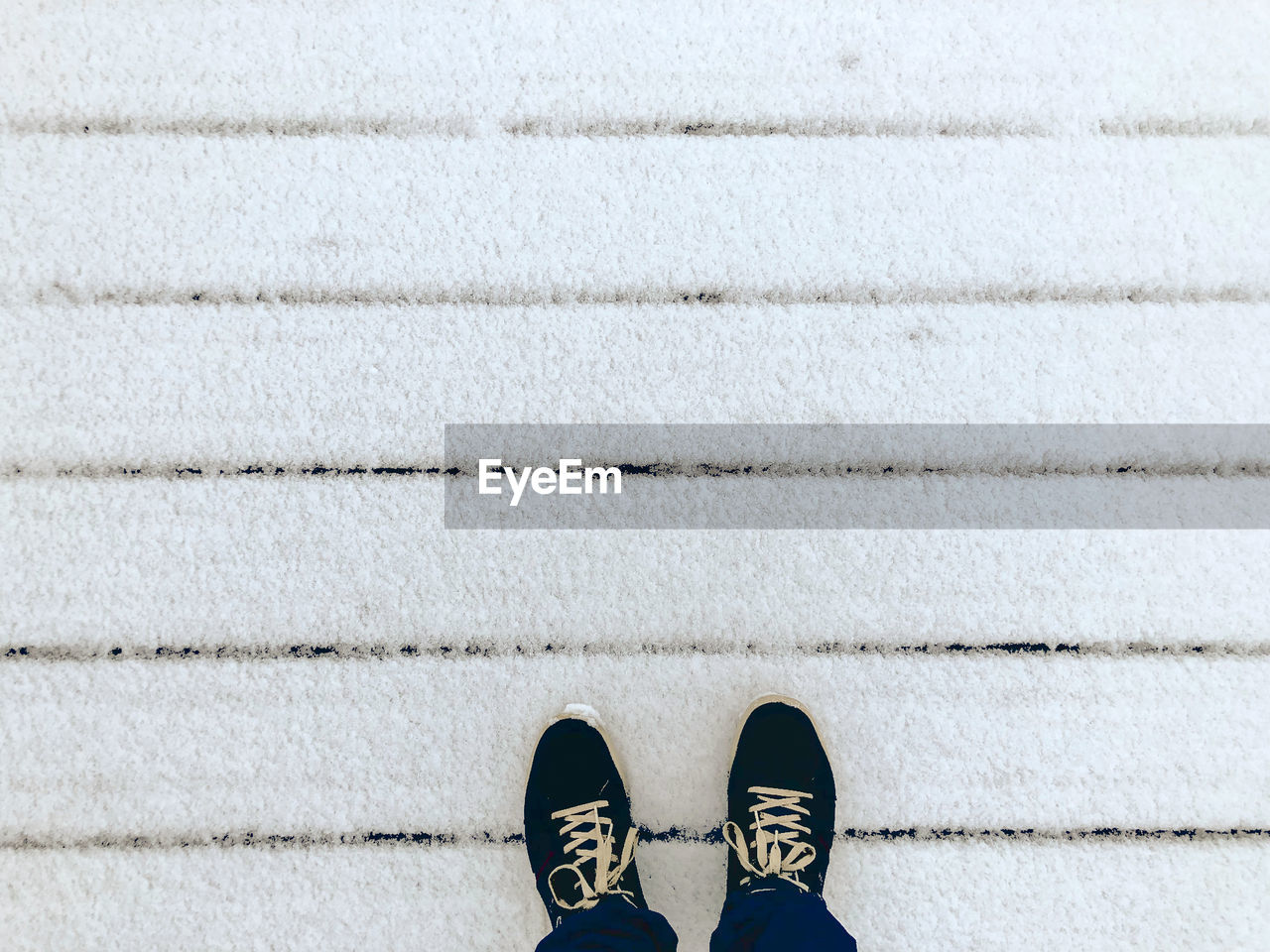 Low section of person standing on tiled floor