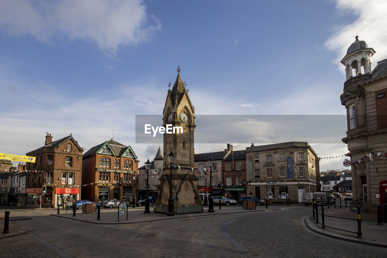 architecture, building exterior, town, built structure, city, sky, cityscape, travel destinations, building, street, urban area, town square, landmark, cloud, nature, tower, travel, religion, place of worship, the past, history, downtown, tourism, clock tower, transportation, city street, belief, road, plaza, clock, city life, neighbourhood, spirituality, outdoors, old, group of people, evening, mode of transportation, day, old town
