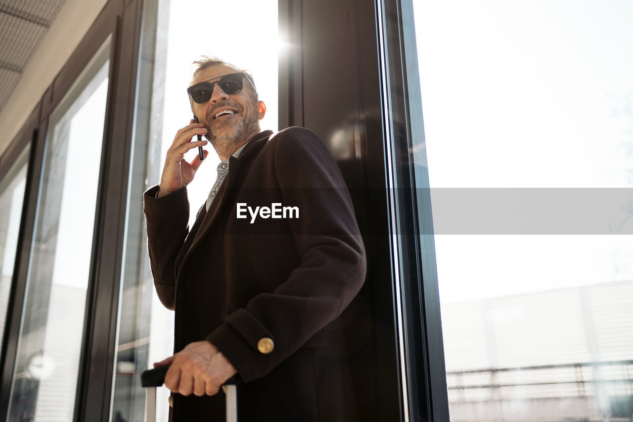 Man using mobile phone at window