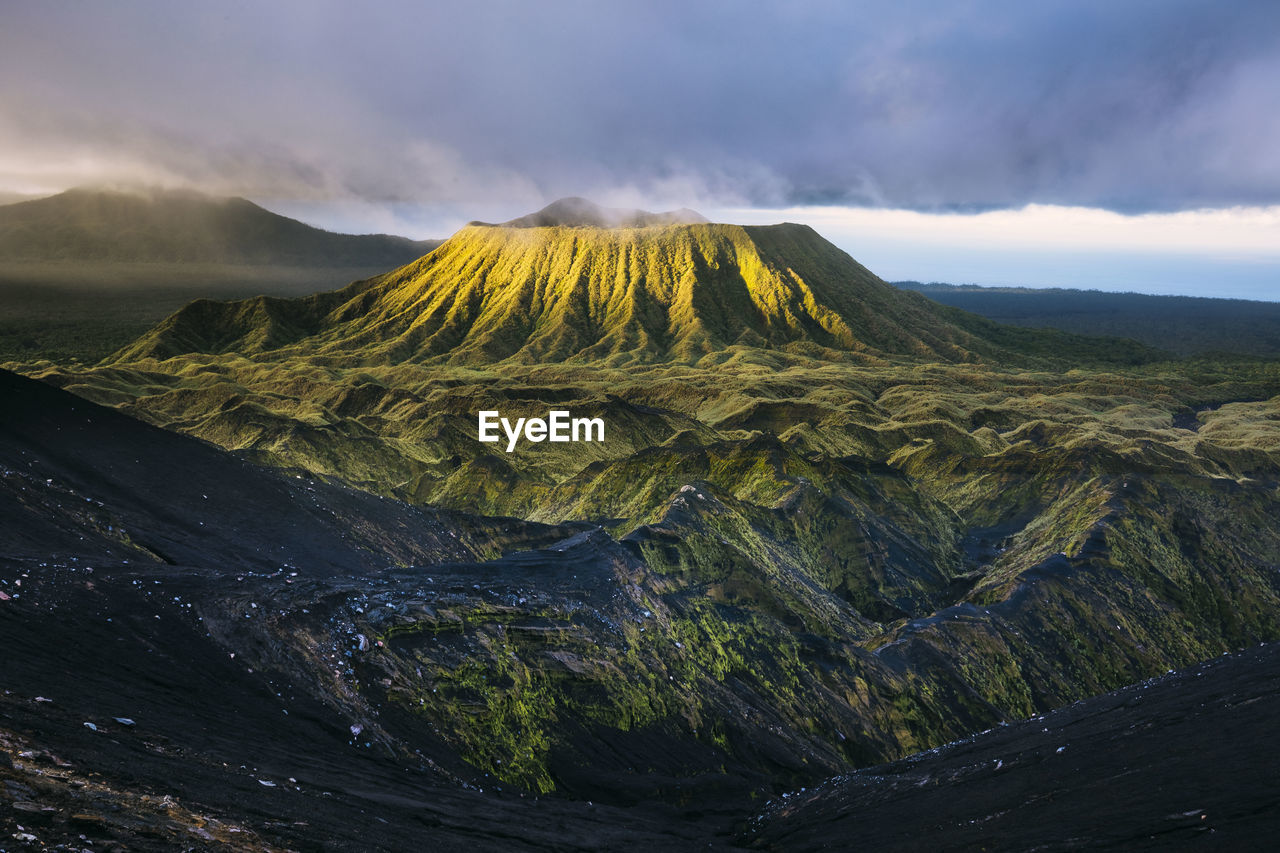 Scenic view of volcanic crater against cloudy sky