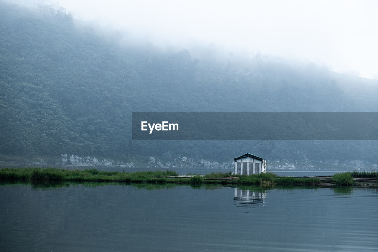 SCENIC VIEW OF LAKE BY SNOW COVERED LANDSCAPE