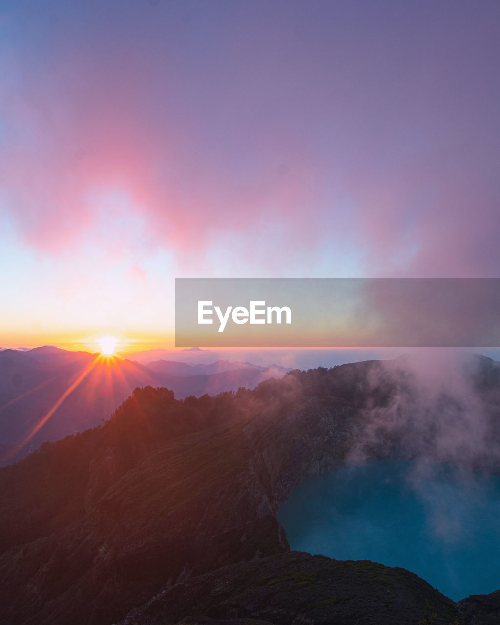 Scenic view of volcano crater and mountains against sky during sunrise