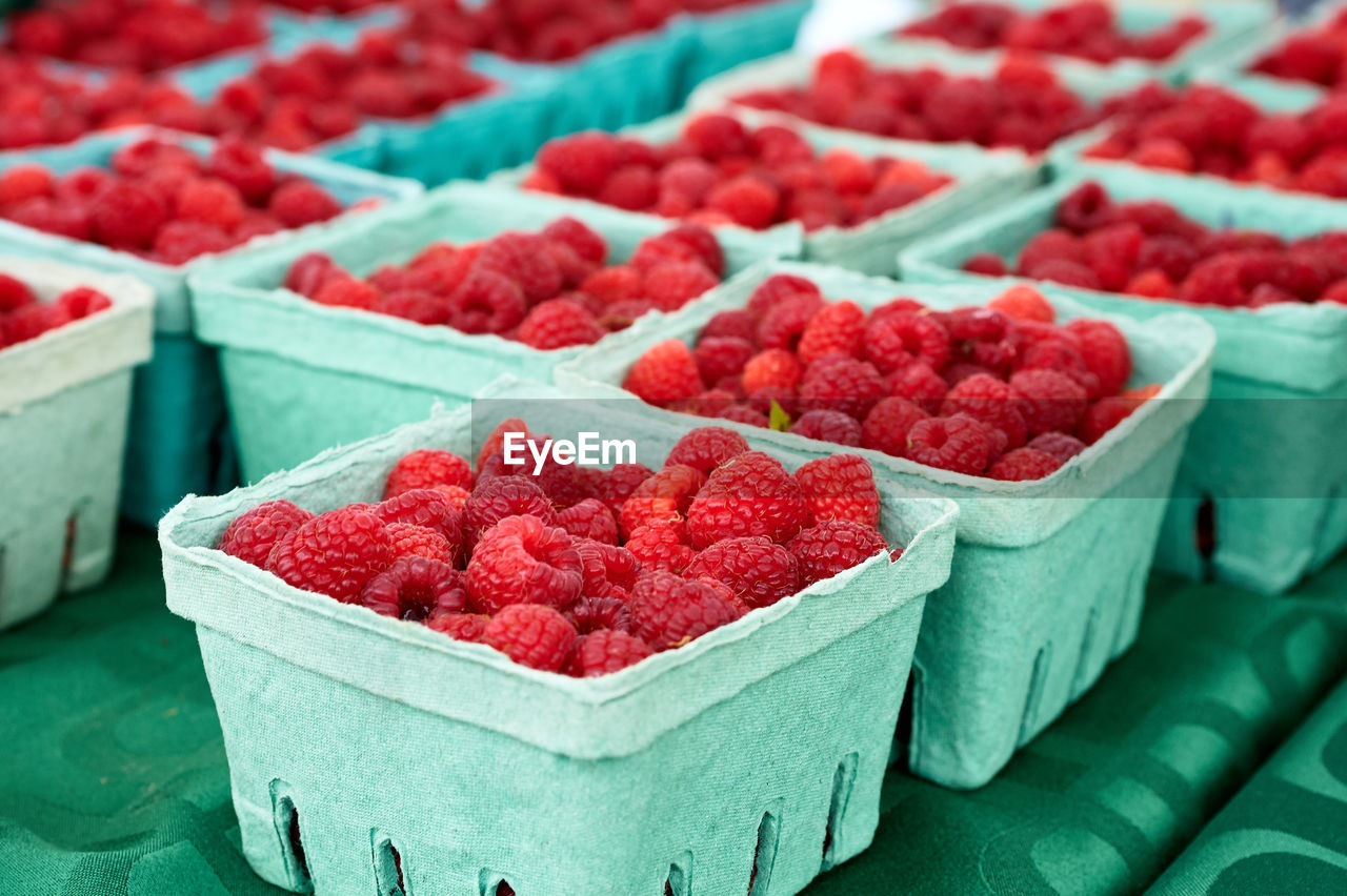 Fresh raspberries for sale on market stall