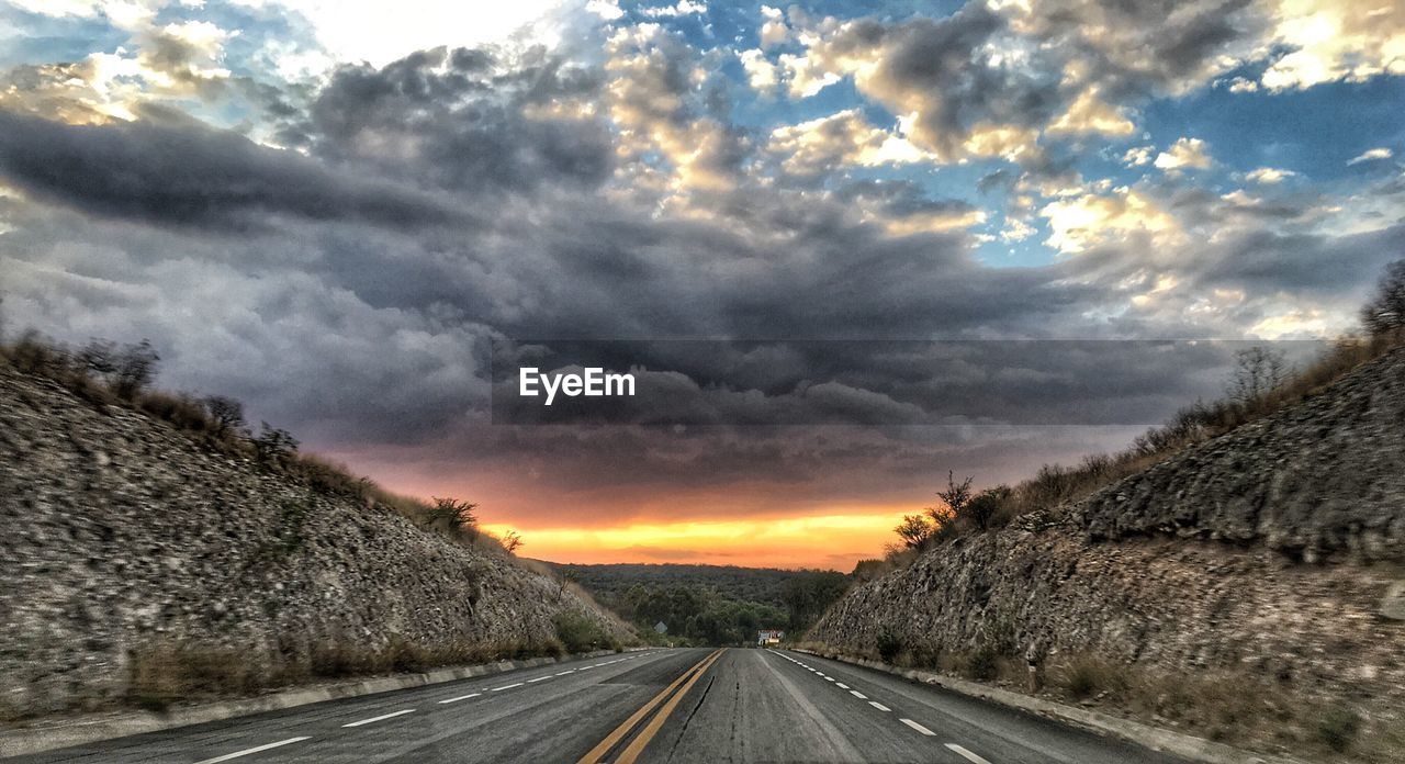 ROAD BY LANDSCAPE AGAINST SKY DURING SUNSET