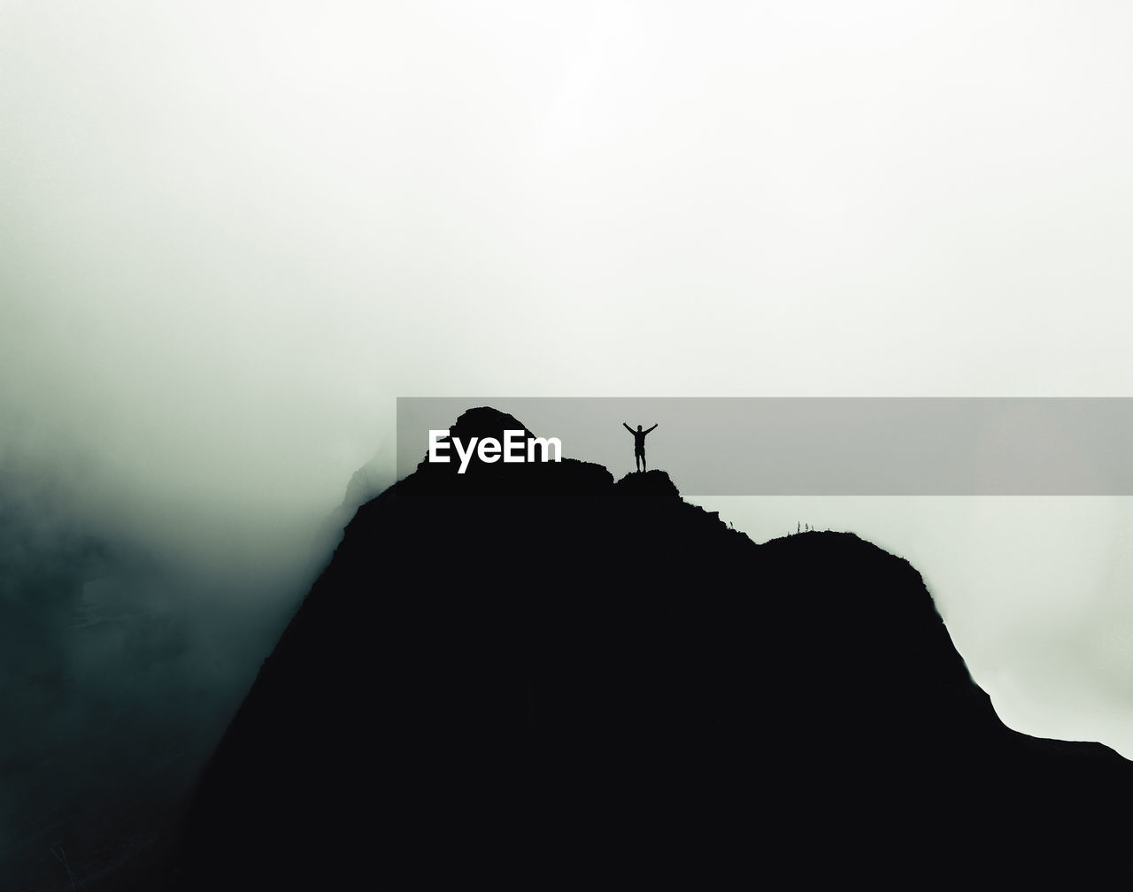 Silhouette of rock on mountain against sky