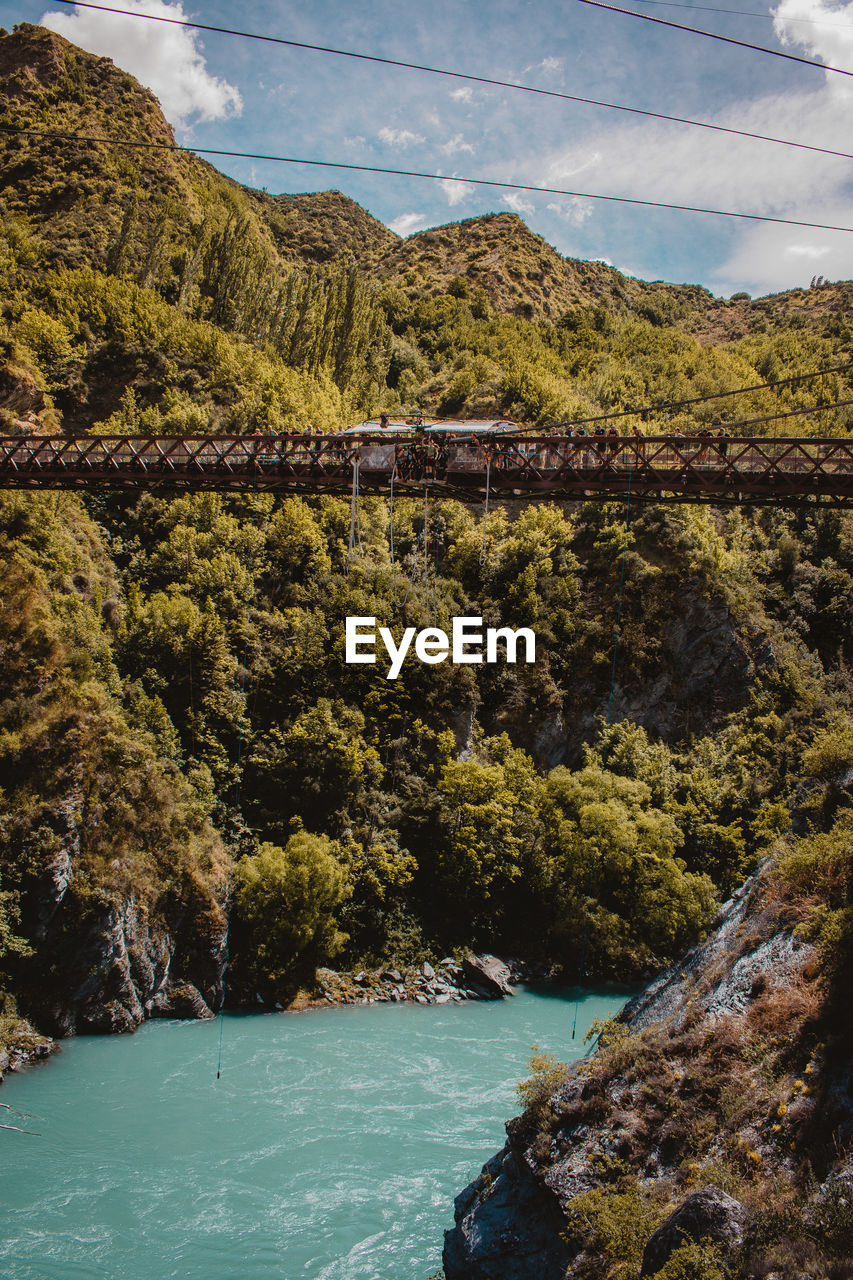 Scenic view of river by mountains against sky