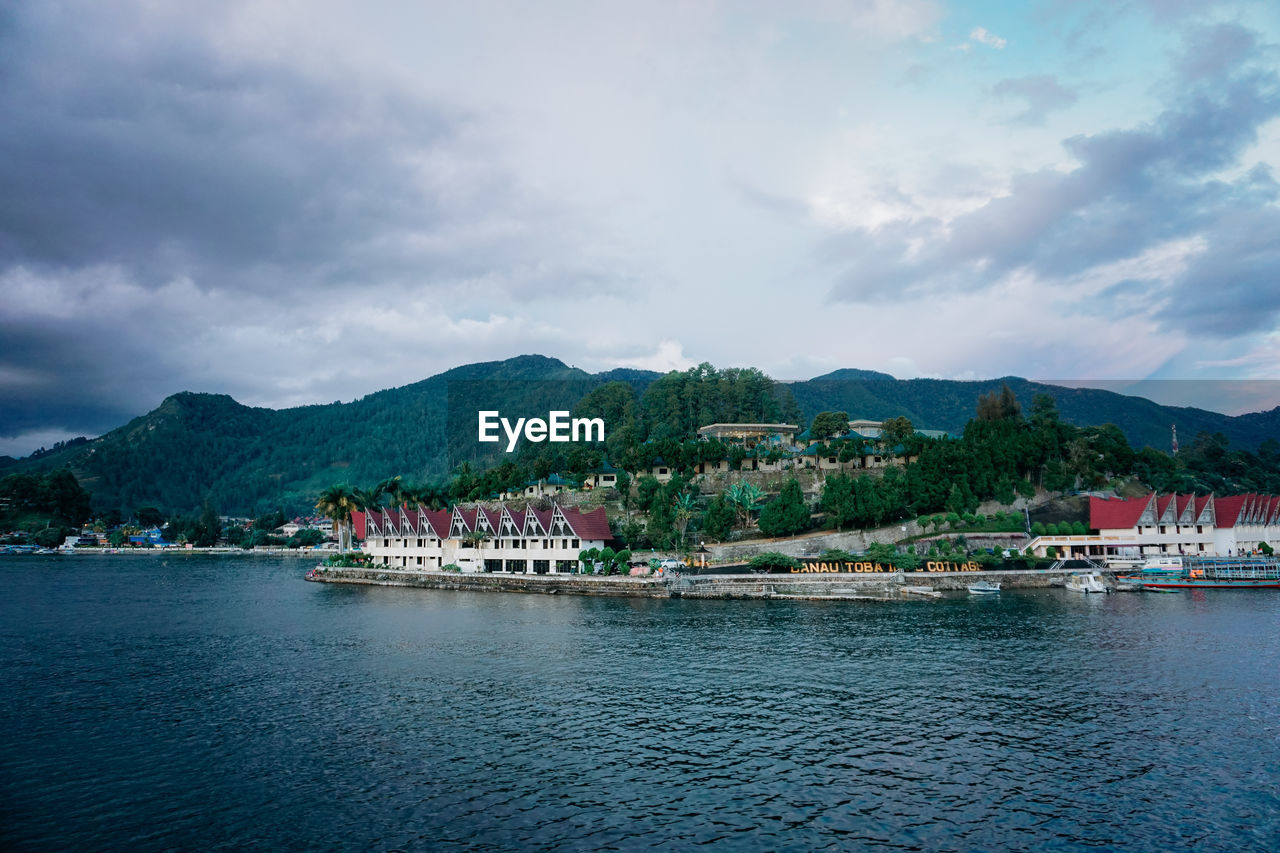 Scenic view of sea by buildings against sky