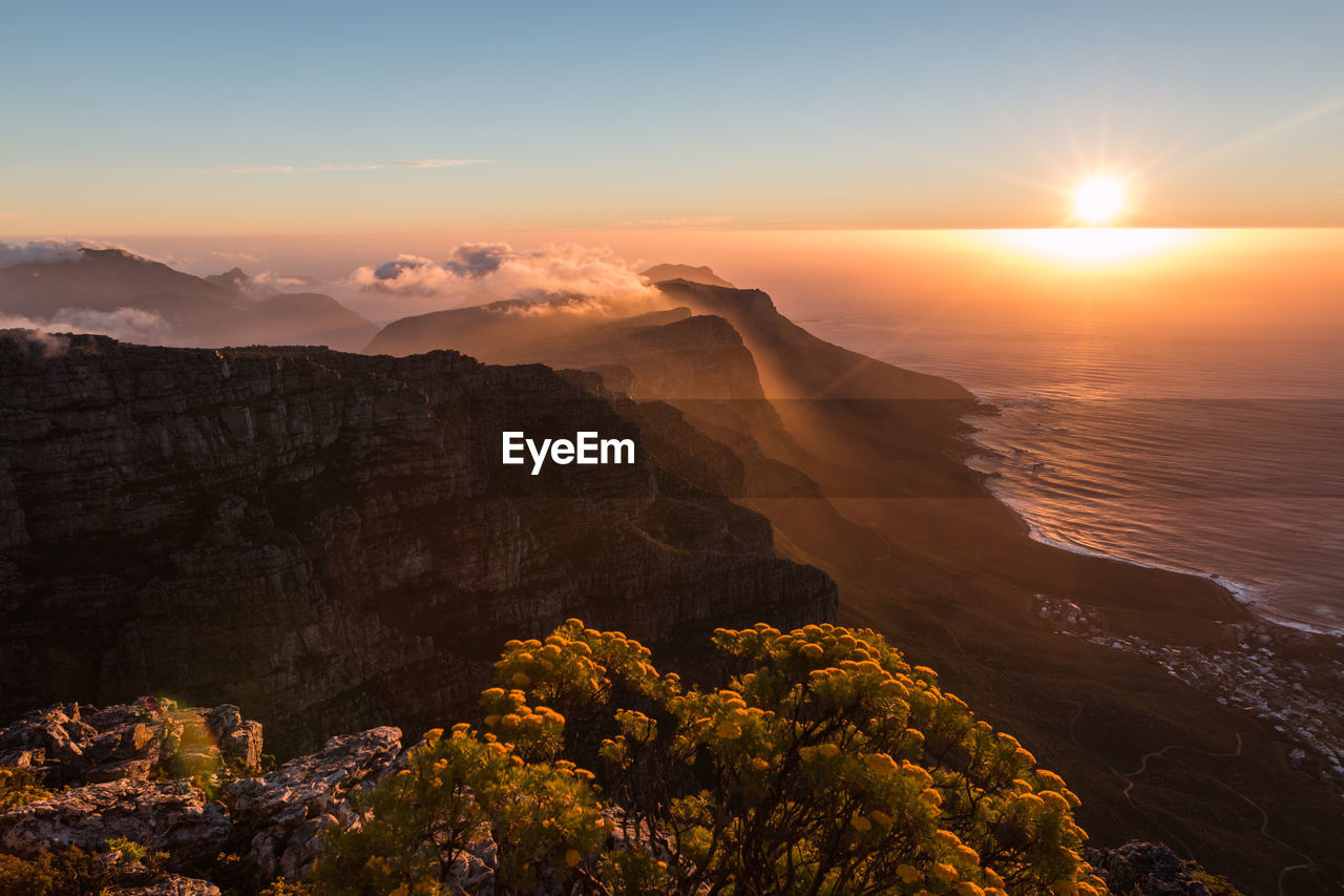 Scenic view of mountains and sea against sky during sunset