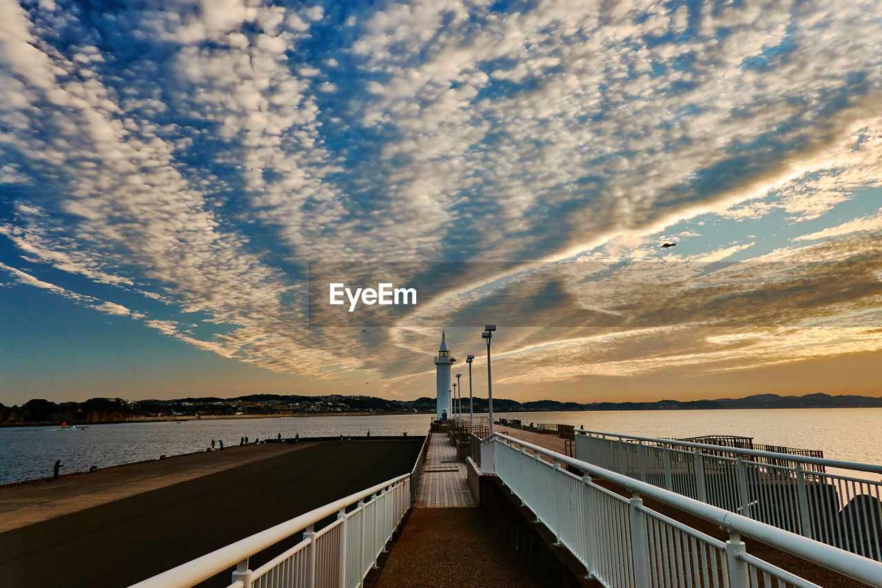 Pier over sea against sky during sunrise